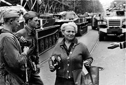 Жінка з портретом Людвіга Свободи і Олександра Дубчека біля радянських солдатів